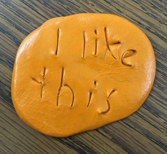 Screenshot of a zoom call with Rhys on the right and a young blond boy and his mother on the left. The boy is smiling and signing 'more'